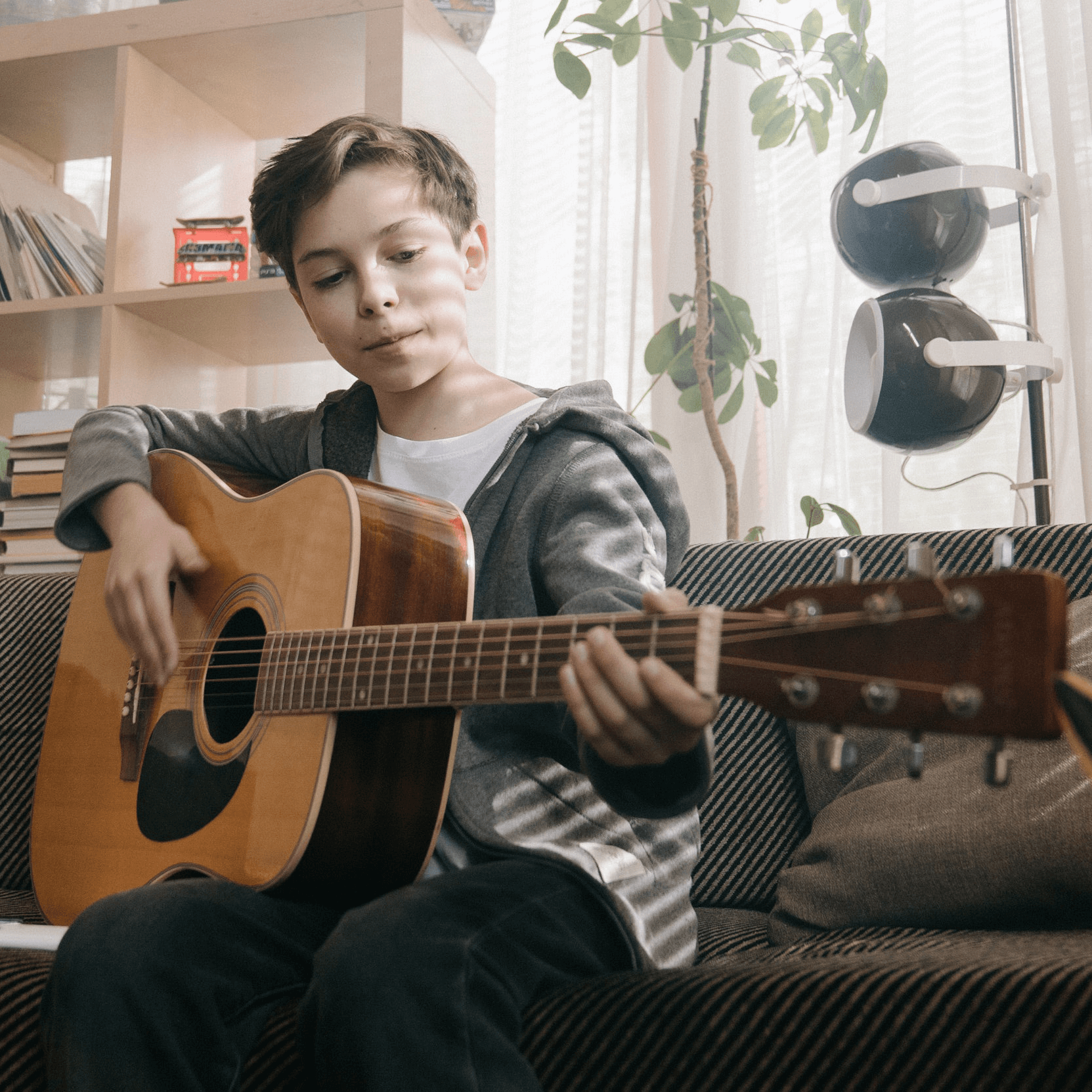Boy playing guitar at home